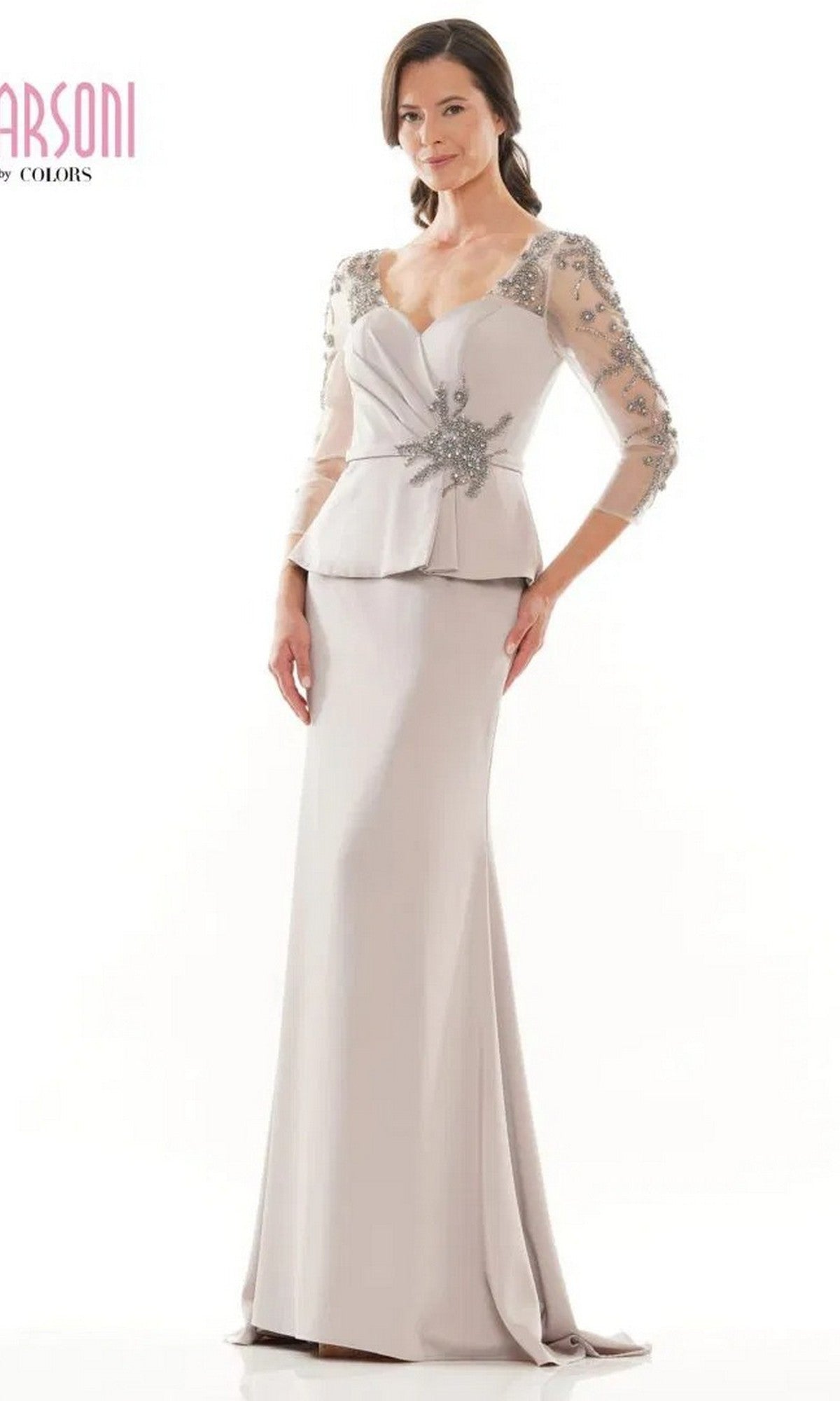A woman poses against a white background wearing the Long Formal Dress: Marsoni MV1037 in silver, featuring sheer embellished sleeves and a decorative waist detail.
